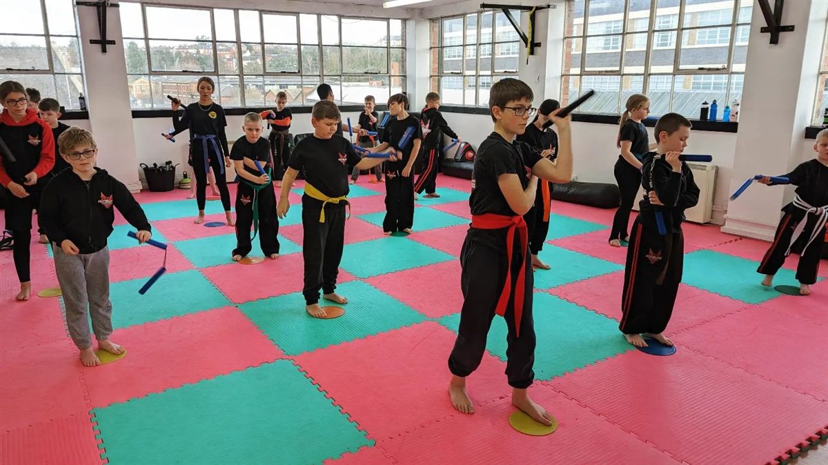Children practising martial arts together in a Kitsune class